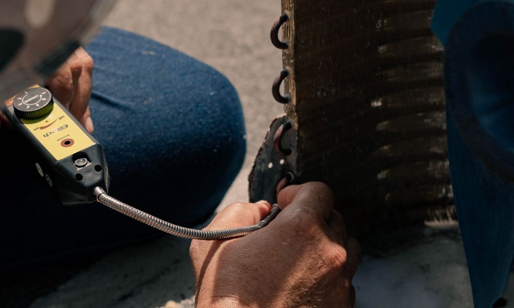 Technician servicing an indoor air conditioning unit during a repair visit